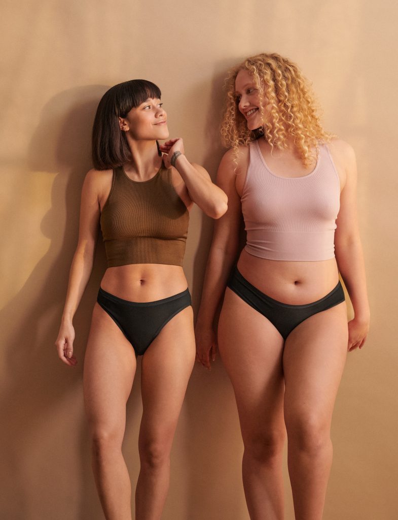 Women wearing sustainable period underwear with a confident smile, promoting leak-free protection